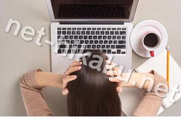 パソコンを見て頭を抱える女性
